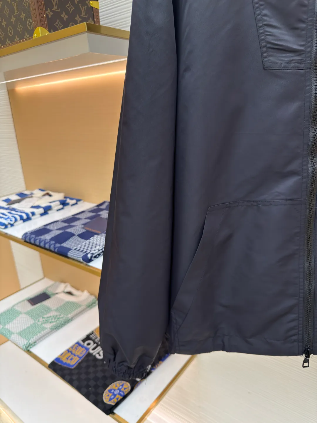 LOUIS VUITTON double-sided windproof pin jacket ●Authentic product: purchased and developed for 22800 ●Item number: 1680472-C55 ●Fabric: polyester fiber fabric ●Technology: jacquard ●Version: fitted version ●Weight: about 565 grams ●Size: 44-46-48-50 ●Description: The solid color fabric is made of nylon encrypted matt twill fabric, and the jacquard fabric on the other side is made of 50D nylon yarn-dyed jacquard fabric. The solid color front panel is laser-burned, hand-made of white copper, with a triangle pin with logo and glossy finish. The front panel pocket uses a hardware keychain to hang a folding clothing tag, and the jacquard letters on the front chest placket are made of single-piece flowing pure It is cut by hand to restore the flower, and all the pieces are numbered. The pockets are also cut with the restored flower number. The fabric is relatively light and silky, and it takes time to cut accurately. The front and center are equipped with a double-circulation puller 5# orbital zipper. The hem and the hood are worn with spiral elastic ropes with ring anti-slip buckles, square pig nose buckles with logo, and all holes are punched with hardware and logo on the cloth-colored cornrows.